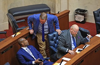 Sen. Bryan King (center), R-Green Forest, speaks with Sen. Fred Love (left), D-Mabelvale, as Sen. Steve Crowell, R-Magnolia looks at documents before the start of a session in the Senate Chamber at the state Capitol on Monday, April 15, 2024. (Arkansas Democrat-Gazette/Colin Murphey)